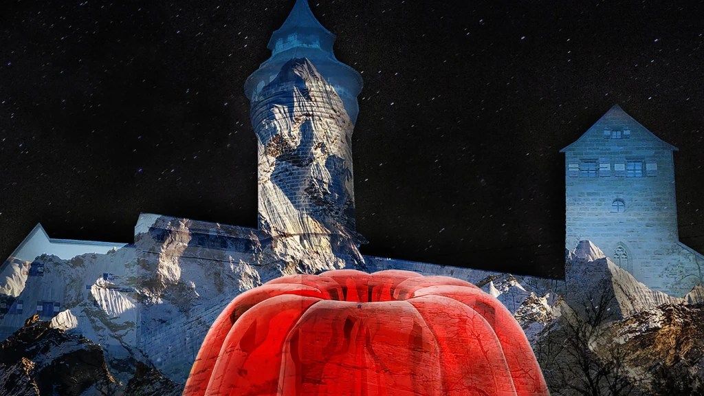 Bei der Blauen Nacht Nürnberg 2025 wird eine Berglandschaft und roter Wackelpudding  auf die Kaiserburg projiziert