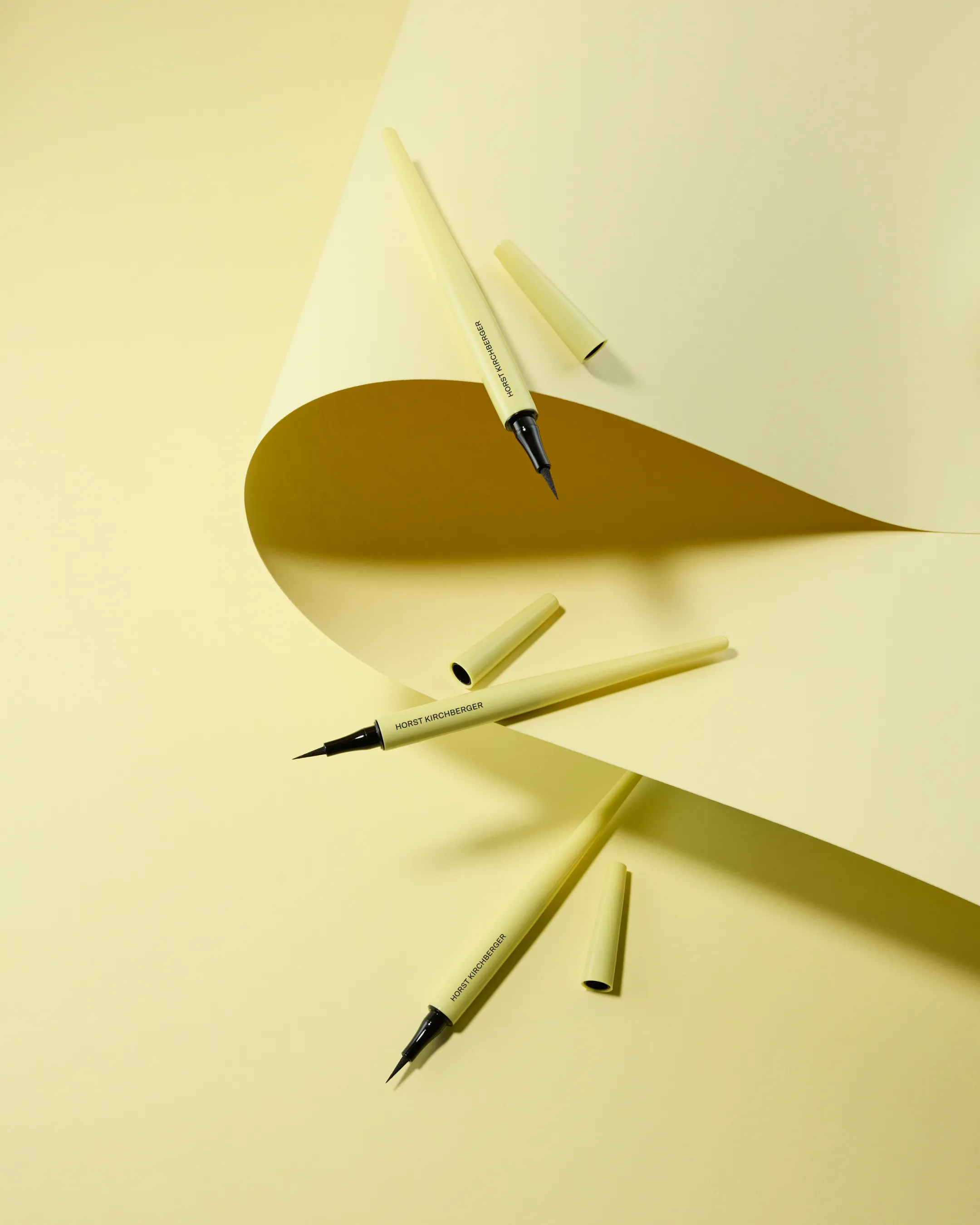Gelbe offene Eyeliner von Horst Kirchberger inszeniert mit pastell gelbem Papier und Hintergrund