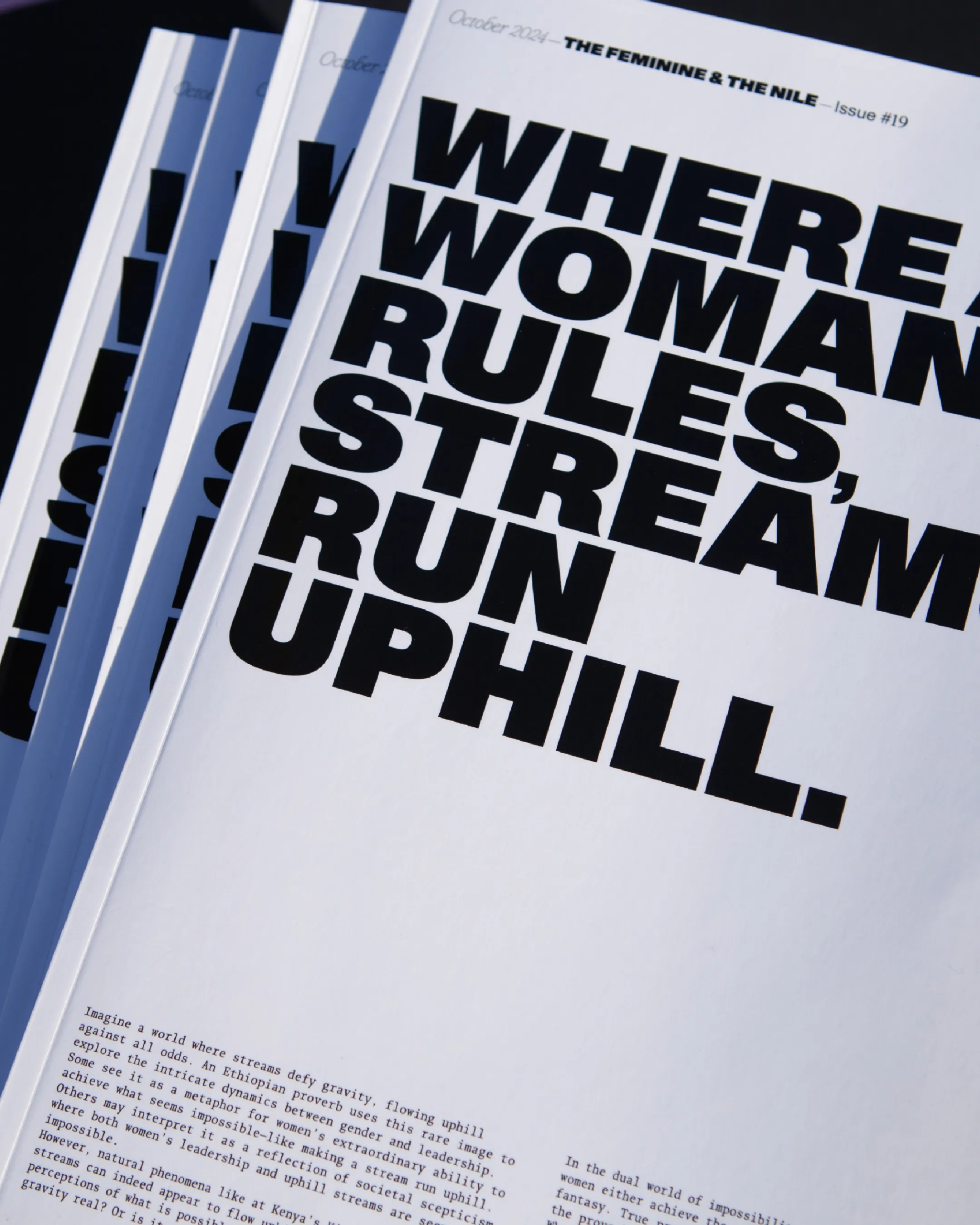 Nahaufnahme des Magazincovers mit schwarzer bolder Typografie auf weiß. Titel: Where a woman rules streams run uphill.